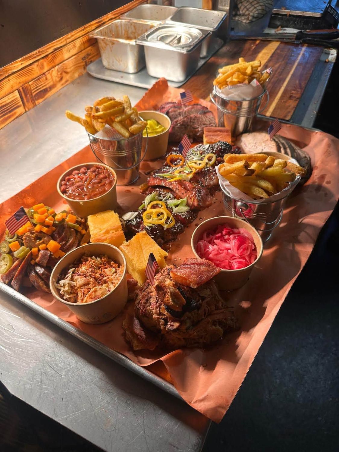 A loaded Lone Star Barbeque platter — brisket, hot link, pulled pork and sides on butcher paper