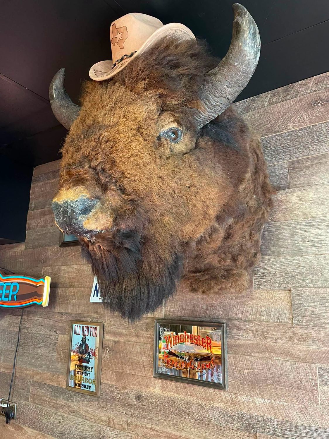 The mounted bison head over the pit — Lone Star Barbeque's Texas signage inside the shop
