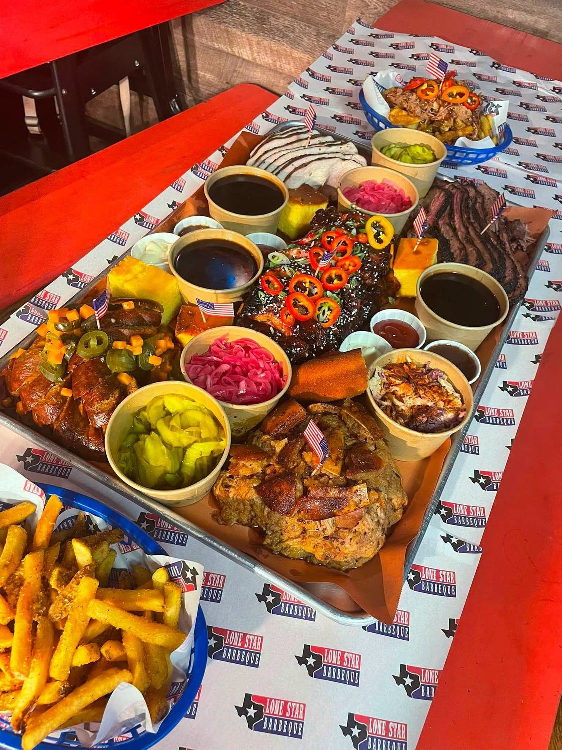 The Wild West platter — brisket, pulled pork and hot link with sides on a tray